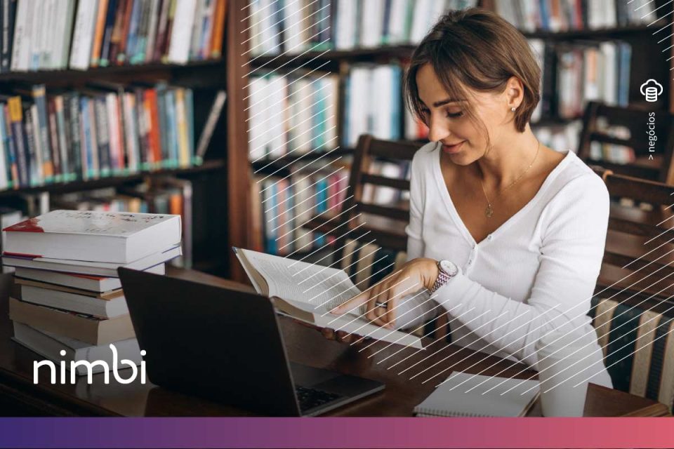 Na imagem, vemos uma mulher estudando em meio a uma biblioteca, cercada por livros e um laptop, simbolizando a busca por conhecimento sobre livros sobre gestão de compras. O ambiente remete à dedicação em aprender e aprimorar habilidades na área, reforçando a importância de estar atualizado em práticas eficientes de gestão para alcançar melhores resultados na administração de compras.